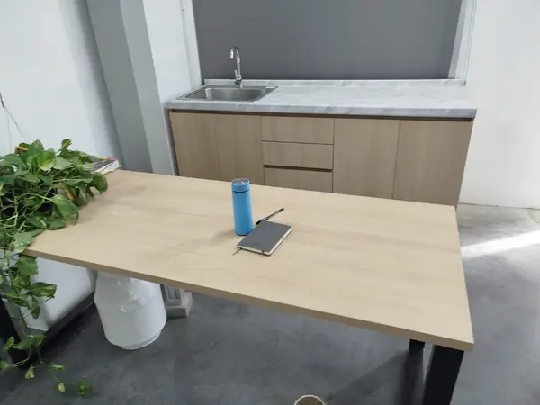 Mesa de apoyo con base metálica junto a la cocineta fabricada por Ofichap
